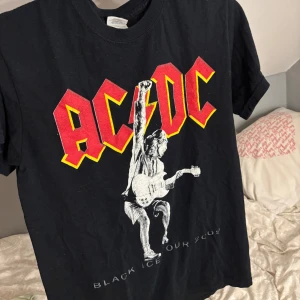 AC/DC Black Ice Tour 2009 t-shirt - Svart AC/DC t-shirt med stort tryck fram och bak från Black Ice Tour 2009. Fint skick i storlek S.