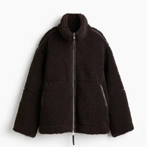 Brun teddyjacka hm  - Mysig brun teddyjacka med hög krage och hel dragkedja framtill. Jackan har två stora fickor och en oversized passform som ger en chill vibe. Perfekt för kalla dagar när du vill vara både varm och snygg.  