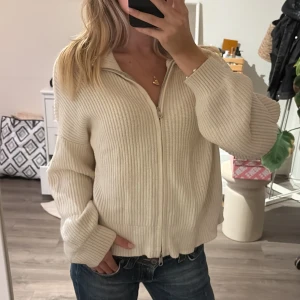 Stickad dragkedje tröja - säljer denna fina krämvita stickade med dragkedja, går även att bära helt öppen! aldrig använd från stradivarius