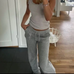 Gråa juicy Couture byxor  - Supermysiga grå mjukisbyxor från Juicy Couture med snörning i midjan, stora fickor med knappar och broderad JC-logga. Byxorna har en relaxed passform och är perfekta för chill dagar. Tillverkade i mjukt bomullsmaterial. De är i storlek 10-11 men passar xxs/xs lika bra 