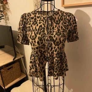 Leopardmönstrad blus från Gina Tricot - Supersnygg blus från Gina young med leopardmönster och rosetter framtill. Storlek 158-164 (passar mig som har s i tröjor) inga synliga defekter❤️
