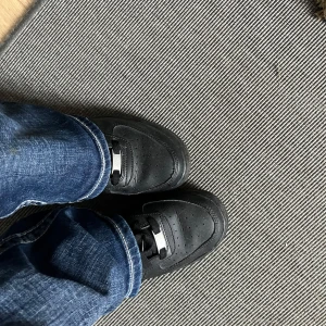 Svarta Nike Air Force 1 sneakers - Klassiska helsvarta Nike Air Force 1 sneakers i skinn med perforerad tå och svarta skosnören. Snygg och tidlös modell med låg profil och metallbricka med 'AF1' på snörningen. Super fina, använt runt 5 gånger