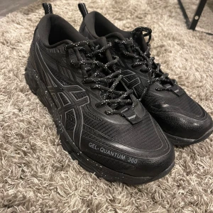 Svarta Asics Gel-Quantum 360 sneakers - Svarta Asics Gel-Quantum 360 sneakers med coola reflekterande detaljer och svartvitprickade skosnören. Ovandel i mesh och syntet, robust sula med vita stänk och tydlig Asics-logga på sidan. Perfekta för dig som gillar sportig och modern stil. Går att pruta, pris ej hugget i sten :)