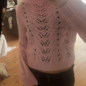 Rosa stickad tröja från H&M - Söt rosa stickad tröja från H&M i storlek M. Tröjan har ett öppet, hålstickat mönster framtill och är croppad med långa ärmar och ribbade muddar. TRYCK INTE PÅ KÖP KNAPPEN TAR BARA SWISH 💓