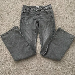 Grå jeans från Gina Tricot - Snygga grå jeans från Gina Tricot i klassisk  femficksmodell. Jeansen är bootcut och lågmidjade. Passar dig som är 162 och kortare. Perfekta till sneakers eller boots och funkar året runt.