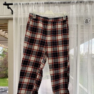 Rutig byxa från Jack & Jones S - Snygga rutiga byxor från Jack & Jones i storlek S. Byxorna har ett klassiskt röd, svart och vit rutmönster och är gjorda i mjuk bomull. Perfekta för en chill och avslappnad stil.