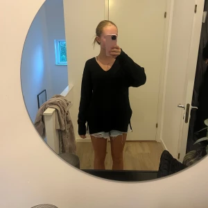 Svart stickad v-ringad tröja H&M strl Xs - Svart stickad tröja från H&M i oversized modell med v-ringning och långa ärmar. Tröjan har slitsar i sidorna och är perfekt för lager-på-lager. Enkel och stilren design som funkar till allt. Strl Xs 💗