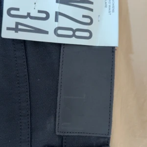 Svarta bootcut jeans Tiger of Sweden - Snygga svarta jeans från Tiger of Sweden med bootcut-modell och klassisk femficksdesign. Jeansen har medelhög midja och är tillverkade i ett stretchigt bomullsmaterial som sitter skönt. Perfekta för dig som gillar en stilren och tidlös look.