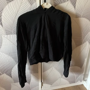 Svart hoodie med huva - Säljer en svart hoodie med lång ärm och huva. Tröjan har en enkel och stilren design utan synliga loggor eller mönster. Skriv för flera bilder. 