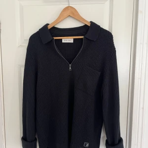Svart stickad tröja med half zip Pier One - Svart ribbstickad tröja från Pier One med krage och half zip-dragkedja framtill. Tröjan har en bröstficka och är långärmad, perfekt för lager-på-lager. Materialet är mjukt och skönt i syntet. Snygg och enkel att matcha till det mesta. Storlek M, passar L också. Knappt använd
