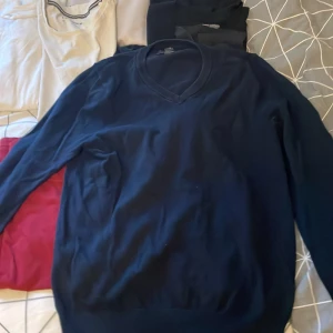 Mörkblå bomullströja från M&S - Snygg mörkblå tröja från M&S i 100% bomull. Klassisk v-ringning och långärmad modell som passar perfekt till jeans eller chinos. Enkel och stilren design som funkar året runt. Perfekt för dig som gillar en clean och tidlös look.