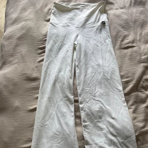 Vita ribbade vida byxor i M - Säljer ett par vita ribbade byxor med hög midja och vida ben. Byxorna är stretchiga och ribbade till för träning och passar perfekt för mig som är 175cm!🤍🤍🤍Aldrig använda från lager 157