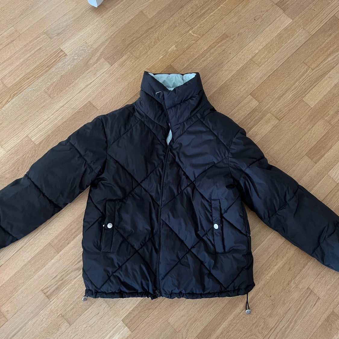 Vändbar pufferjacka svart och ljusblå