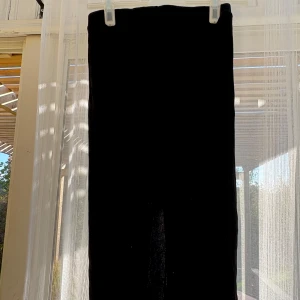 Svart ribbad kjol - Svart ribbad kjol från Lager 157. Kjolen har en mjuk och stretchig känsla, perfekt för dig som gillar en bekväm men ändå trendig look. Snygg slitt bak