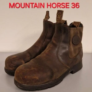 Bruna ridstövletter Mountain Horse 36 - Korta bruna stövletter från Mountain Horse i äkta läder. Klassisk modell med rund tå, kraftig sula och dragflikar fram och bak. Perfekta för ridning och stall, robusta och slitstarka med snyggt sliten look.Priset är förhandlingsbart