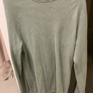 Grön stickad tröja från Jack & Jones - Snygg ljusgrön stickad tröja från Jack & Jones i storlek S. Tröjan har en enkel och stilren design med rund halsringning och lång ärm. Perfekt för lager-på-lager och chill vardagsstil. Den ser lite pösig ut nu på bild men skicka dm så löser vi mer där! ANVÄND 2ggr