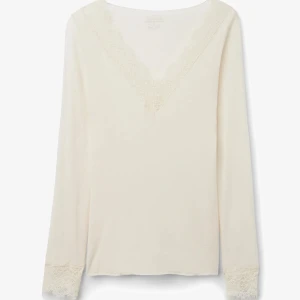 Intimissimi tröja  - Superfin vit långärmad blus med v-ringning och spetsdetaljer både vid halsringningen och vid ärmsluten. Toppens mjuka material gör den extra skön och den har en clean, stilren look som passar till många outfits.