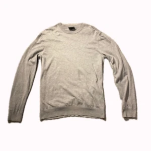 Grå slim fit tröja från H&M - En stilren grå tröja från H&M i slim fit-modell. Tröjan har rund halsringning, långa ärmar och är tillverkad i mjukt material som passar perfekt till lager-på-lager. Enkel och clean look som funkar till det mesta. 9/10 skick