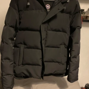 Canada Goose jacka MacMillan - svart canada goose MacMillan parka. Supervarm och skön och en perfekt vinterjacka. Jackan är använd i en månad i vintras, och är i nyskick. Säljer pga att jag gått ner i vikt och den passar tyvärr inte längre
