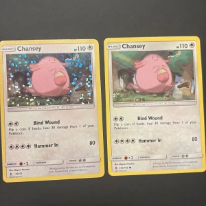 Chansey - Två coola Chansey Pokémonkort! Perfekt för samlare eller dig som vill boosta din lek. Ena kortet är holo och båda har 110 HP och attacker som Bind Wound och Hammer In. Färgglada och i fint skick – ett måste för alla Pokémonfans!