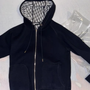 Svart hoodie med mönstrad huva - Svart hoodie till salu nytt sick då jag köpte fel storlek säljs för 1500 med påse storlek M