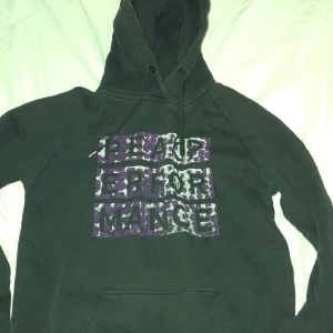 Svart hoodie från peak performance - Svart hoodie med stor huva och snörning från . peak performance Framsidan har ett unikt tryck i lila och grått med prickigt mönster. Klassisk känguruficka och långärmad modell, perfekt för en chill och avslappnad stil.