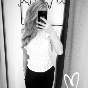 Vit blus med volangärmar Holly & Whyte - Supersöt vit blus från Holly & Whyte med strukturmönster och volangiga korta ärmar. Blusen har rund halsringning och ett diskret knäpp bak i nacken. Perfekt för dig som gillar romantiska detaljer och en luftig känsla.