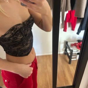 Svart spetskorsett från SHEIN - Säljer en snygg svart korsett från SHEIN med spets och fodrad kupa i beige. Toppen är axelbandslös och har bandeauform, med fina detaljer i spets och mesh. Perfekt för att lyfta din outfit med en edgy vibe. 