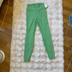 Gröna scrunch leggings från SOC XS - Snygga gröna leggings från SOC i storlek XS med scrunch-detalj bak. Hög midja och tight passform, perfekta för träning eller chill. Tillverkade i mjukt och stretchigt material som sitter skönt hela dagen.