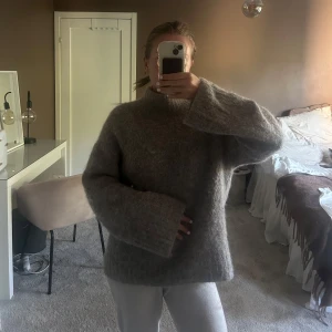 Beige stickad tröja från Selected Femme - Mysig beige stickad tröja från Selected Femme med hög hals och breda ärmar. Tröjan har en loose fit och är perfekt för kyliga dagar. Den är fluffig och har en enkel, stilren look som passar till allt. Storlek M nypris 1100kr säljs för 900kr+frakt.