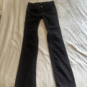 Svarta jeans från Lee - Snygga svarta jeans från Lee med klassisk femficksdesign och Lee-logga på bakfickan. Jeansen har rak passform och är tillverkade i ett mjukt denimtyg som sitter skönt hela dagen. Perfekta till en avslappnad streetstil.