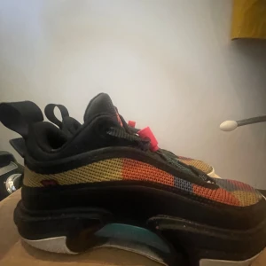 Nike Jordan 6 sneakers med färgglada detaljer - Nike Jordan 6 sneakers med mesh-paneler i gult, rött, blått och svart. Snygga detaljer som speckled midsole, dragflik med rosa text och klassisk Air-dämpning. Rund tå och platt sula för skön komfort. Kommer med originalbox med Jumpman-logga.