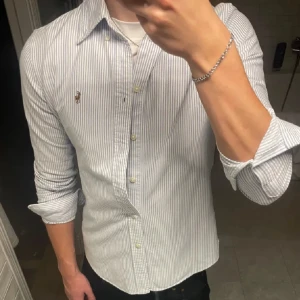 Polo Ralph Lauren skjorta  - Stilren skjorta från Polo Ralph Lauren. I nyskick, inga defekter. Passar dig som är 170-180 bäst. Slimfit. Storlek S men lutar definitivt mot XS. Jag är 179 på bilden. 