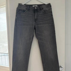 Grå jeans från Pull&Bear, straight fit - Snygga grå jeans från Pull&Bear i klassisk straight fit. Jeansen har fem fickor, bälteshällor och knappgylf. Materialet är robust denim i en mörkgrå tvätt som ger en cool, avslappnad vibe. Perfekta för dig som gillar en enkel men stilren look. Storlek 40 men skulle säga att den är som 38 i storleken. Super fina jeans, som nya aldrig använt eftersom de ej passade mig. Pris kan aldrig diskuteras 
