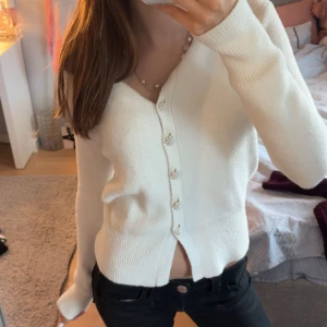 Vit kofta med pärlknappar - Superfin vit kofta med v-ringning och långa ärmar. Koftan har snygga pärlknappar framtill som ger en extra touch. Mjuk och skön stickad känsla, perfekt att slänga på sig över ett linne eller t-shirt. Hör av er vid några frågor! Accepterar dem flesta buden! 💕