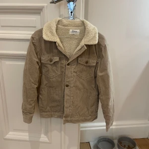 Beige manchesterjacka från Bonpoint 14år - Säljer en snygg beige manchesterjacka från Bonpoint med mysig teddykrage och foder. Jackan har två bröstfickor med knappar, klassisk passform och detaljer i bronsfärgade knappar. Perfekt för höst och vinter när du vill vara både varm och stilren. Nypris 3800 vårt pris 899✅ hör av dig om du har några funderingar💫