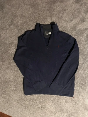 Ralph Lauren quarter zip - Säljer nu en mörkblå quarter zip i bra skick från Ralph Lauren. Tröjan är i Storlek S och passar riktigt bra nu inför vintern för en lite snyggare outfit. 