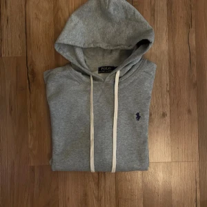  Ralph Lauren hoodie - Snygg grå Ralph lauren hoodie  med klassisk huva och vita dragsnören. 