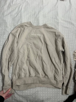 Beige tröja  - Beiga tröja med en liten text 