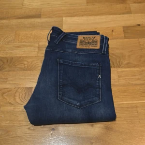 Replay Anbass mörkblå  - Säljer ett par snygga Replay Anbass jeans i mörkblå tvätt. Modellen är slim fit med klassiska fem fickor, snygga detaljer och läderpatch bak. Knappt använda och är i mycket bra skick. W33 L34