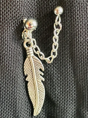 By prisförslag- 1 st Silvrigt dubbel örhänge med fjäder och kedja - Unikt örhänge i silverfärgad metall med en detaljerad fjäderberlock och en tunn kedja som kopplar ihop två kulor. Perfekt för dig som gillar boho eller indie-stil och vill ha något som sticker ut. Snyggt att matcha med andra silversmycken.