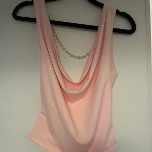 Ljusrosa draperad linnetopp med pärldetalj - Supersöt ljusrosa linnetopp med draperad urringning och snygga pärlband i ryggen🫶🏻