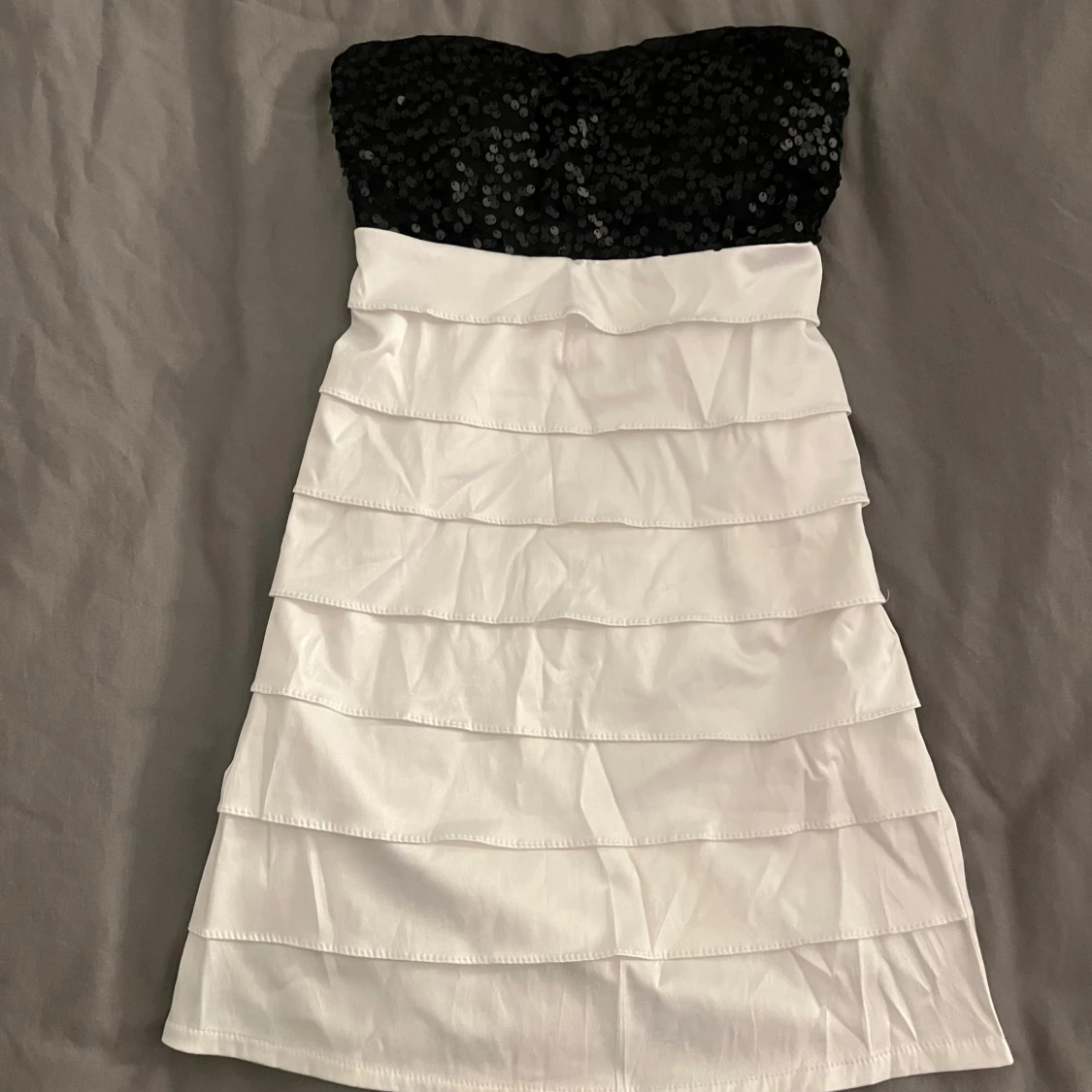 Svartvit axelbandslös paljettklänning