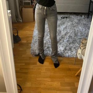 Grå bootcut jeans från Zara, strl 34 med slits  - Säljer ett par grå jeans från Zara i storlek 34. Med en fin slits nedtill och väldigt sköna jeans. Sparsamt använda 