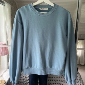 Ljusblå sweatshirt  - Ljusblå sweatshirt från NA-KD med rund halsringning och ribbade muddar. Tröjan har en borstad insida och är i bra skick.