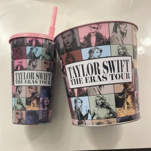 Taylor Swift The Eras Tour - Snyggt souvenirset från Taylor Swift The Eras Tour med en dryckesbägare med sugrör och en popcornhink. Färgglad design med olika bilder från turnén. Perfekt skick, inga synliga skador eller slitage.