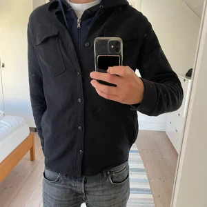 Overshirt från Tiger of Sweden - Svart overshirt från Tiger of Sweden i mycket fint skick. Storlek M, jag på bilden är 188. Modell: Arnou                                                              Passar perfekt för höst och vår. Köpt för 1500kr