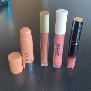 Fyra läpprodukter i nude och rosa toner - Säljer fyra snygga läpprodukter: IsaDora Glossy Lipstick i peachy nude, Max Factor X Lipgloss i skimrande brons, Maybelline Lifter Gloss i rosa, samt Lancôme läppglans i rosabrun nyans. Perfekt för dig som gillar glansiga och mjuka läppar.