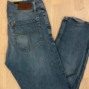Blå slim fit jeans från tiger of sweden - Snygga blå jeans från tiger of sweden. Jeansen är 31/32 fast sitter lite tigth på mig som är 182 och väger 72. Skicket är stabilt utanför att det är 2 små hål ungefär vid bakfickorna. Kan dock lätt lösas genom att sy ihop. Priset kan självklart alltid diskuteras!🙌