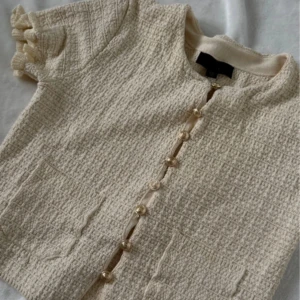 Volangärm tröja med guldknappar - Använd endast en gång